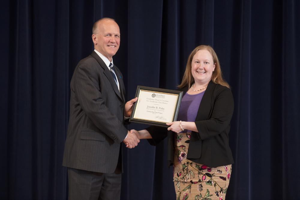 Doctor Potteiger posing for a photo with an award receipient in a black sweater and purple shirt